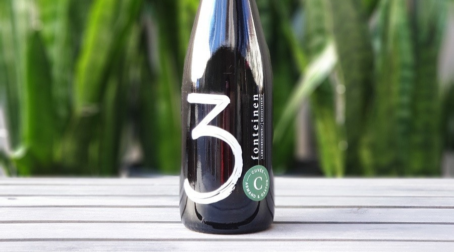bottle of drie fonteinen oude gueze cuvee armand gaston against a grass background